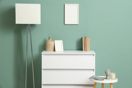Interior of room with white commode, lamp and table