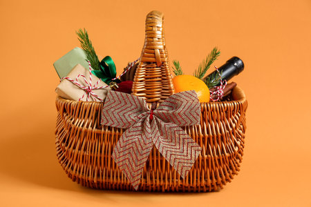 Gift basket with products and Christmas decor on orange backgroundの写真素材