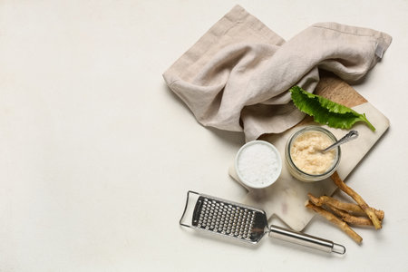 Marble tray, grater and bowl with sauce on white grunge backgroundの写真素材