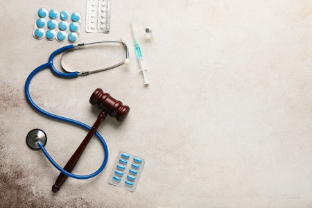 Judge gavel, pills, syringe and stethoscope on white grunge background. Concept of health care reformの写真素材