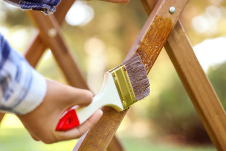Woman painting wooden table in garden, closeupの写真素材