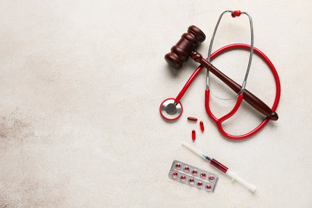 Judge gavel, pills, syringe and stethoscope on white grunge background. Concept of health care reformの写真素材