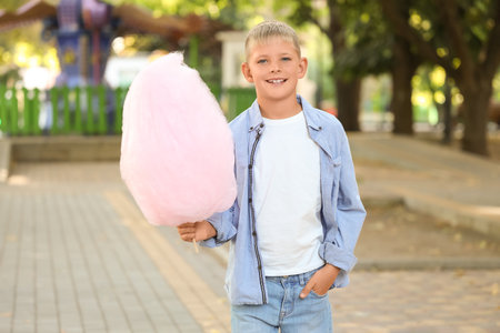 Teen boy with cotton candy in parkの写真素材