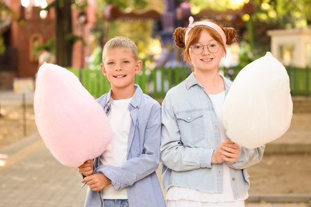 Teen girl and boy with cotton candy in parkの写真素材