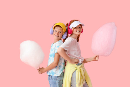 Teen children with cotton candy and headphones on pink backgroundの写真素材