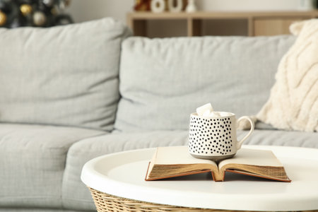 Cup of cocoa with book on table in living room, closeupの写真素材