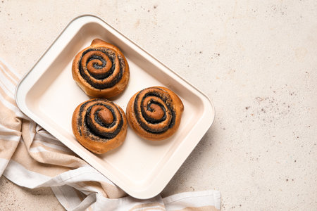 Baking dish with poppy buns on white grunge backgroundの写真素材