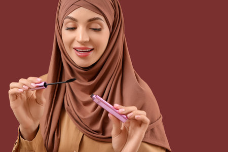 Beautiful Muslim woman with mascara on red background, closeupの写真素材