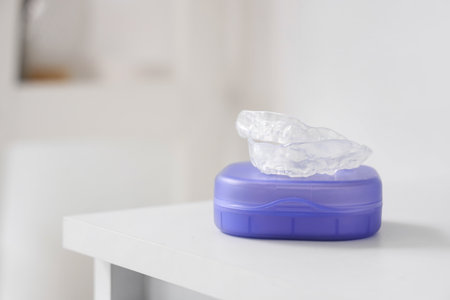 Box with occlusal splint on table in bathroom, closeupの写真素材