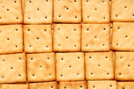 Tasty square crackers as background, closeupの写真素材