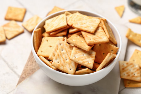 Composition with bowl of tasty crackers on beige background, closeupの写真素材