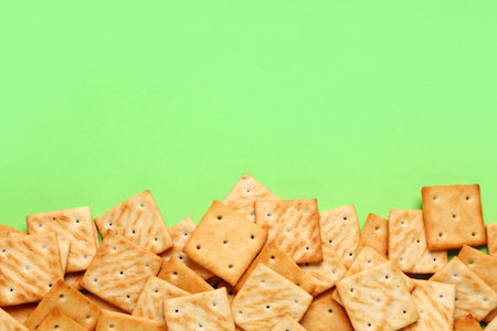 Composition with tasty crackers on green background, closeupの写真素材