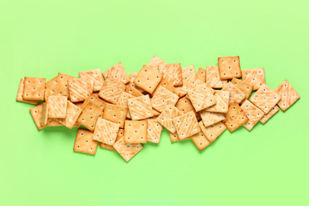 Composition with tasty square crackers on green backgroundの写真素材
