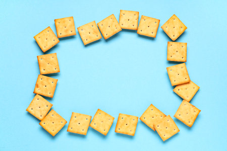Frame made of tasty crackers on blue backgroundの写真素材