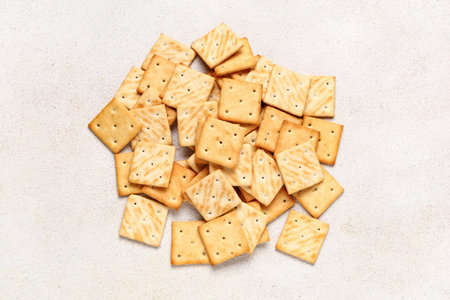 Heap of tasty crackers on beige grunge backgroundの写真素材