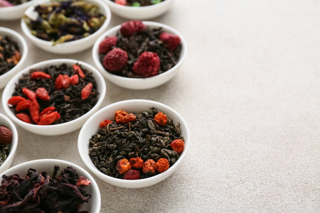 Bowls with different fruit tea on light grunge backgroundの写真素材