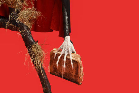 Spooky Halloween monster with book on red background, closeupの写真素材