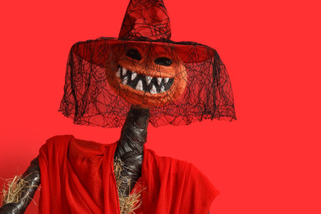 Spooky Halloween monster in witch hat on red backgroundの写真素材