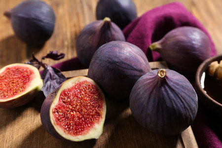 Board with fresh ripe figs on wooden background, closeupの写真素材