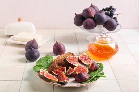 Plate with fresh ripe figs and toasts on white tile backgroundの写真素材