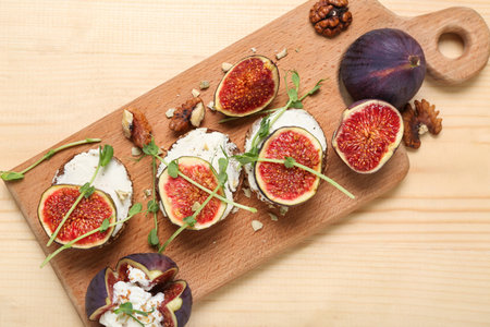 Cutting board, sandwiches with fresh ripe fig and arugula on beige wooden background, closeupの写真素材