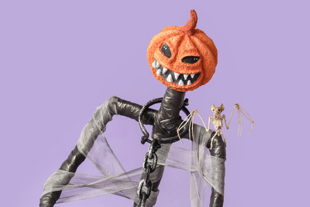 Spooky Halloween monster with bat skeleton on lilac backgroundの写真素材