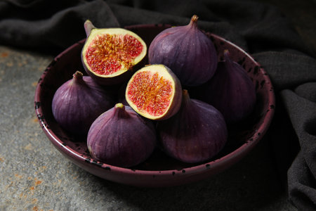Bowl with fresh ripe figs on grunge background, closeupの写真素材