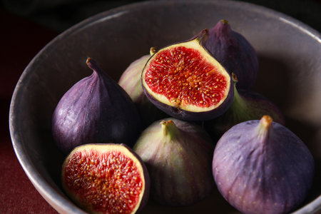 Bowl with fresh ripe figs on red background, closeupの写真素材