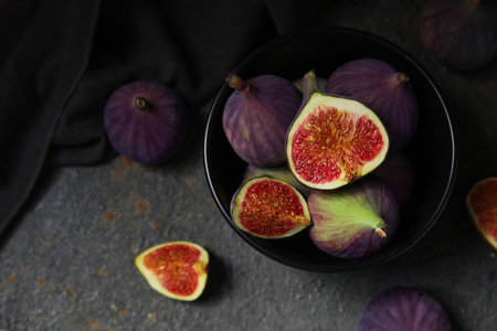 Bowl with fresh ripe figs on grunge backgroundの写真素材