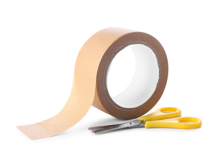 Roll of brown masking tape with scissors on white backgroundの写真素材