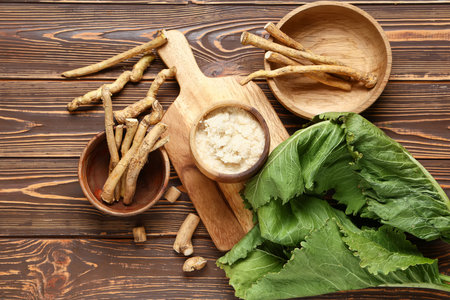 Bowls with roots and green leaves on brown wooden backgroundの写真素材