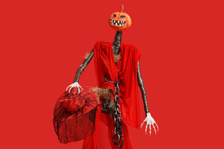Spooky Halloween monster with witch hat on red backgroundの写真素材