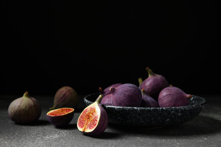 Plate with fresh ripe figs on dark tableの写真素材