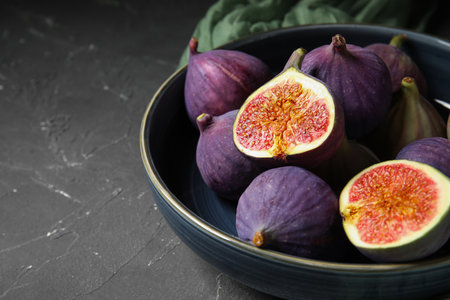 Bowl with fresh ripe figs on black background, closeupの写真素材