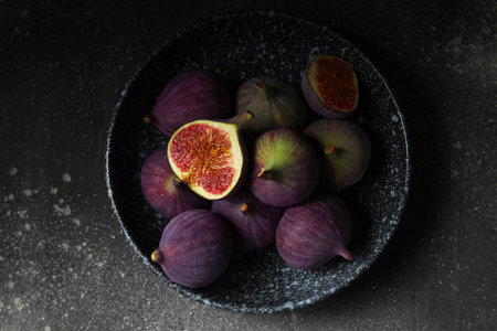 Plate with fresh ripe figs on dark backgroundの写真素材