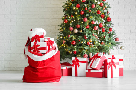 Interior of festive room with Christmas tree and bag full of giftsの写真素材