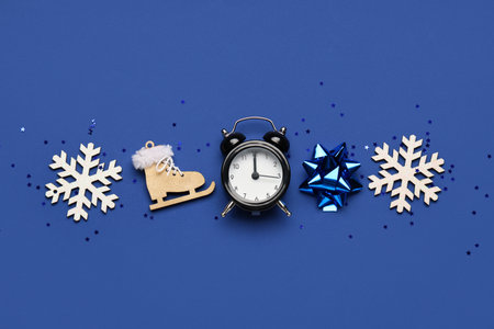 Composition with alarm clock, decorative snowflakes and confetti on blue backgroundの写真素材