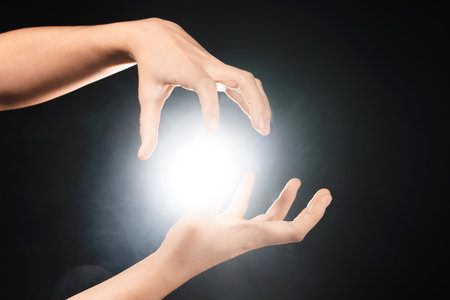 Female hands with ball of energy on black backgroundの写真素材