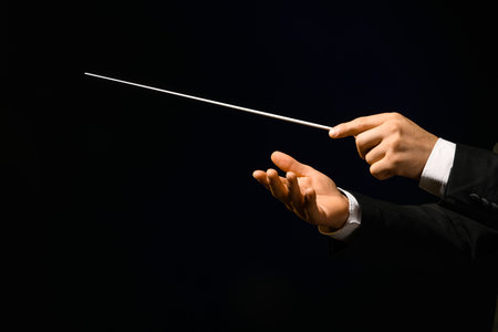 Hands of male conductor with baton on black backgroundの写真素材