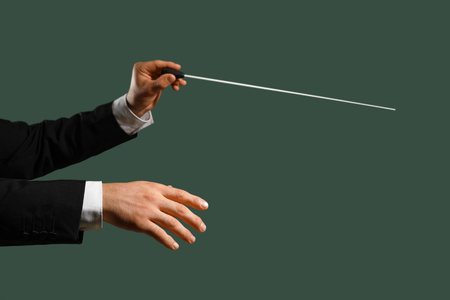 Hands of male conductor with baton on green backgroundの写真素材