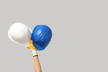 Hands with hardhats on gray backgroundの写真素材