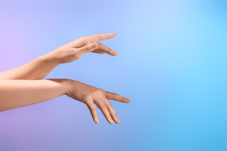 Female hands manipulating energy on blue backgroundの写真素材