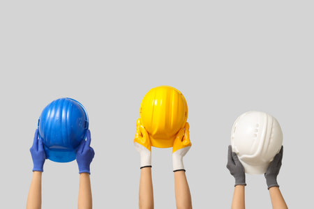Hands with hardhats on gray backgroundの写真素材