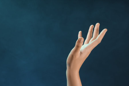 Female hand with blue energy on black backgroundの写真素材