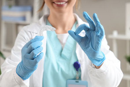 Female dentist with occlusal splint showing OK in clinic, closeupの写真素材
