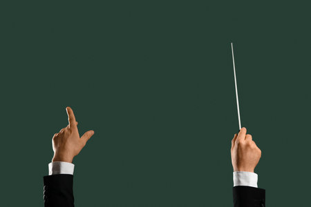 Hands of male conductor with baton on green backgroundの写真素材