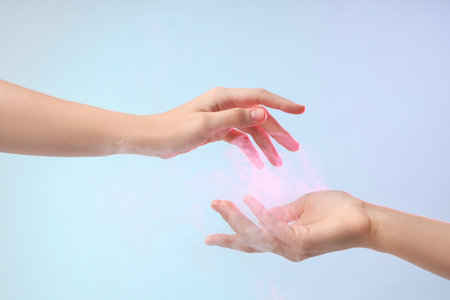 Female hands with ball of pink energy on blue backgroundの写真素材