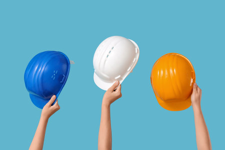 Hands with hardhats on blue backgroundの写真素材