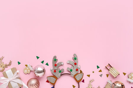 Christmas reindeer antlers headband with gift and decor on pink backgroundの写真素材