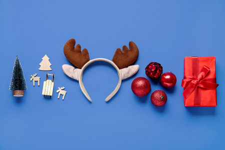 Christmas reindeer antlers headband with gift and decor on blue backgroundの写真素材